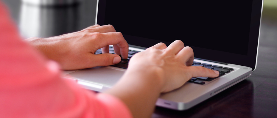 Deux mains tapant sur le clavier d'un ordinateur portable