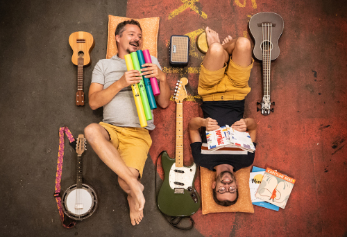 Deux hommes allongés entourés de livres et d'instruments de musique