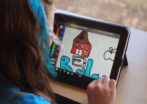 Plan serré sur une enfant dessinant sur une tablette