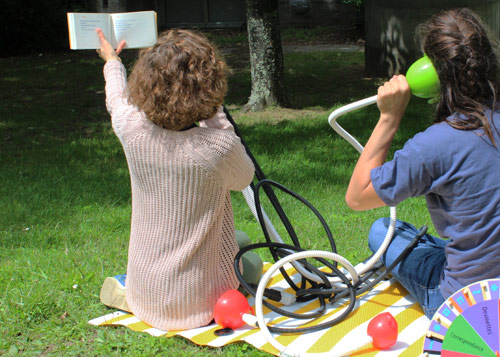 Des bibliothécaires de dos sont assis dans l'herbe