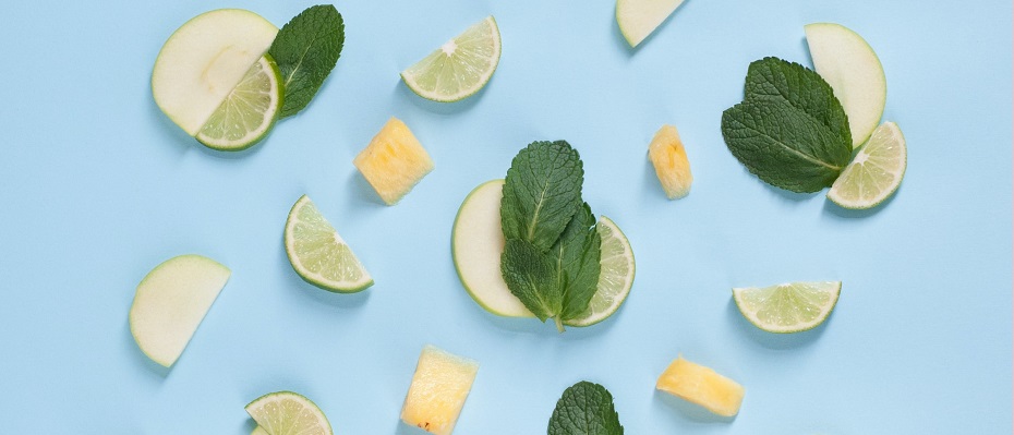 des rondelles de citron, des feuilles de menthe posées sur un fond bleu clair de façon éparpillée