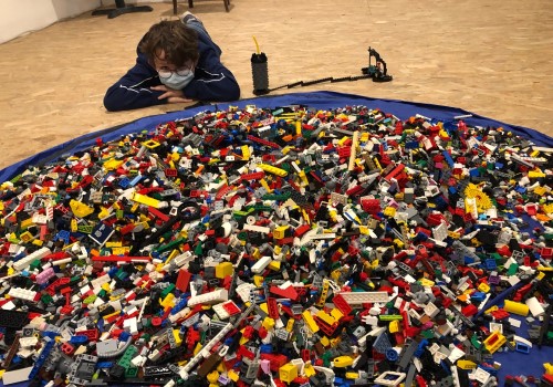 Enfant allongé devant un tapis de Lego