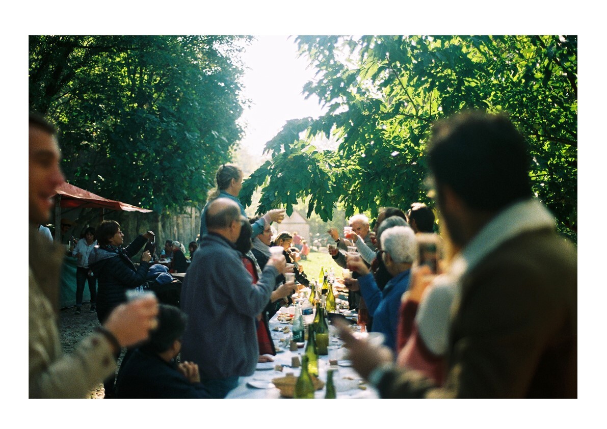 banquet avec grande table centrale et de nombreuses personnes levant leur verre