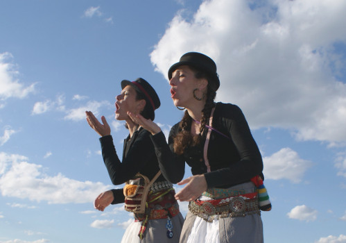 Deus femmes chantent sur fonds de ciel bleu