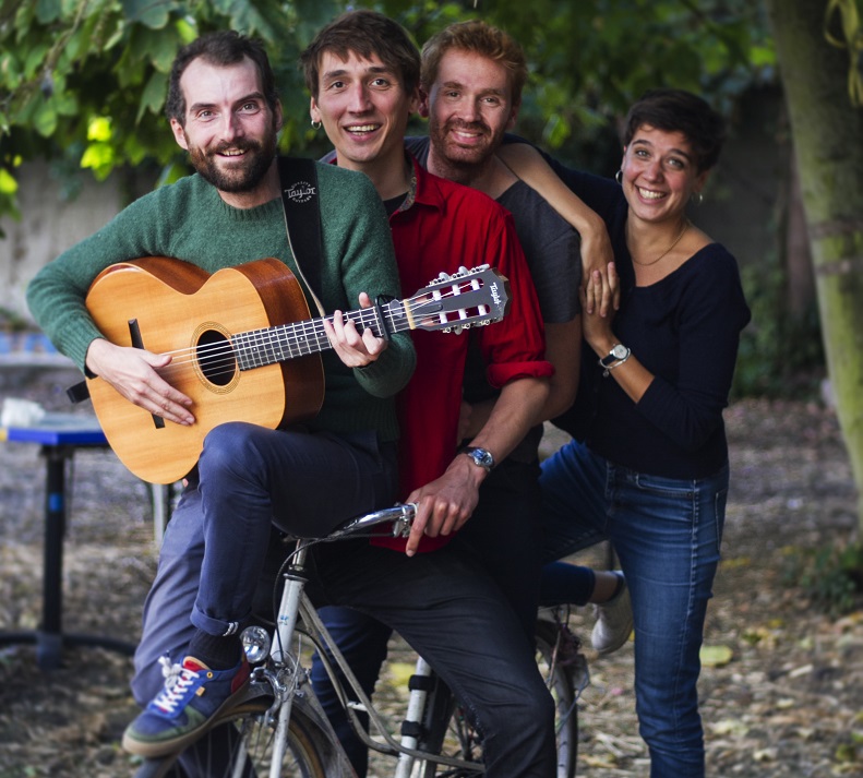 1 femme et 3 hommes sur un vélo avec une guitare 