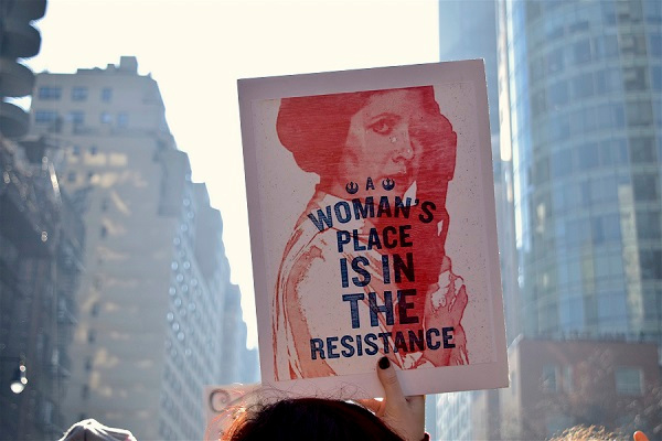femme tenant une pancarte à l'éfigie de princesse Leia dans une manifestation