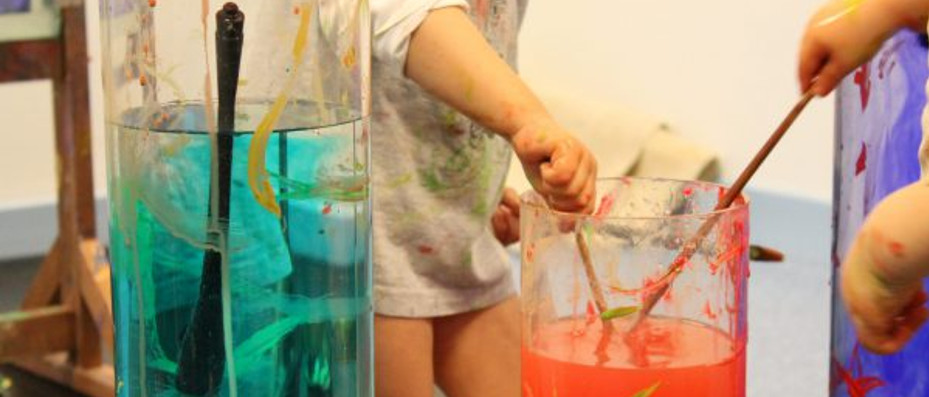 Mains d'enfants, trempant un pinceau dans bac d'eau