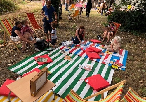 Enfant et parent assis sur un tapis dans un parc