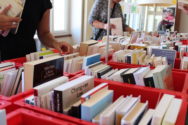 main choisissant des livres dans des caisses