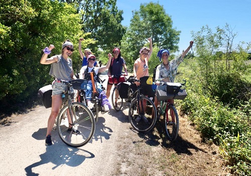 six femmes à vélo posant le poing levé