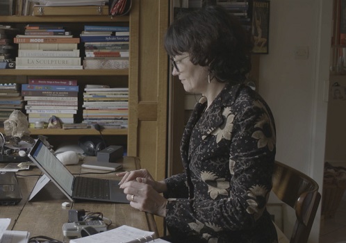 Femme assise à un bureau en train d'écrire
