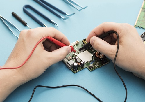 deux mains manipulant un circuit électrique