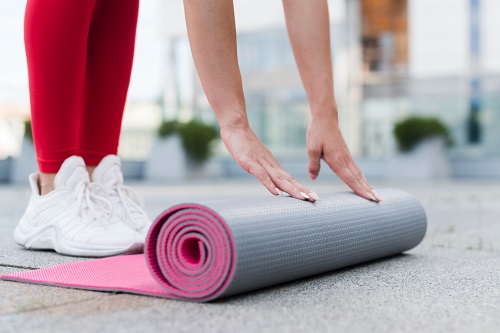 femme s'étirant sur un tapis de gym