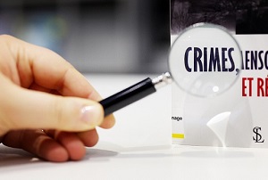 loupe agrandissante posée sur un livre intitulé "crimes..."