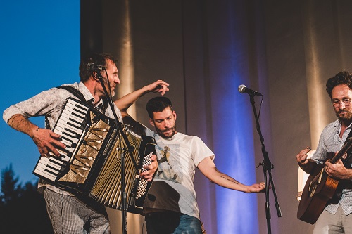 Un accordéoniste un guitariste et un chanteur sur scène