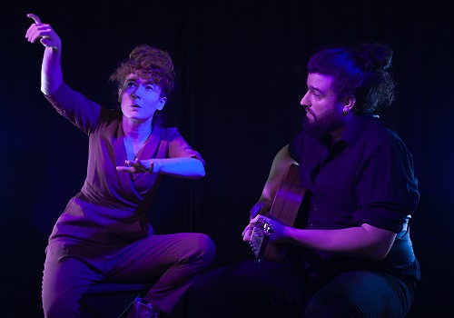 Une femme chansigneuse et un homme jouant de la guitare