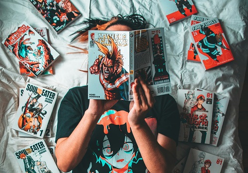 Jeune homme allongé lisant un manga