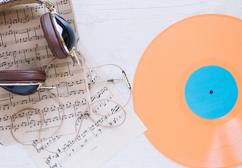 casque audio posé sur des partitions et un vinyle 