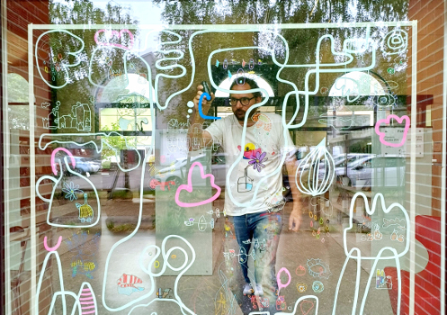 Artiste dessinant sur une vitre