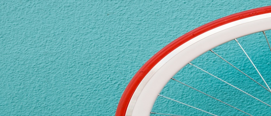 roue de vélo blanche et rouge sur un fond bleu turquoise 