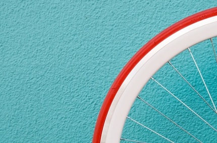 roue de vélo blanche et rouge sur un fond bleu turquoise