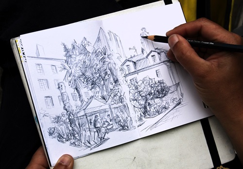 Personne en train de dessiner dans un cahier