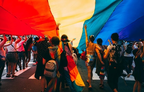personnes tenant le drapeau LGBT lors d'une pride