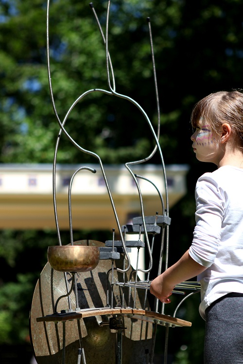 Enfant jouant avec une sculpture musicale