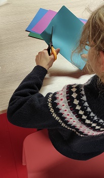 Photographie d'un enfant découpant une feuille